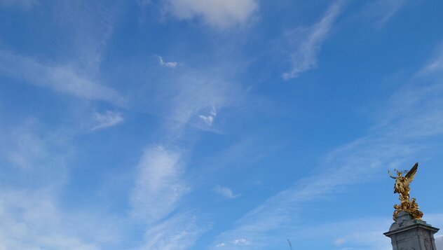 Statue of Nike with some contrails in the background